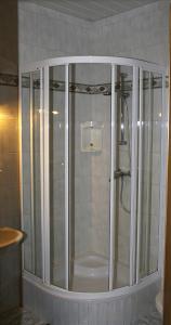 a shower with glass doors in a bathroom at Gasthof Post in Eisentratten