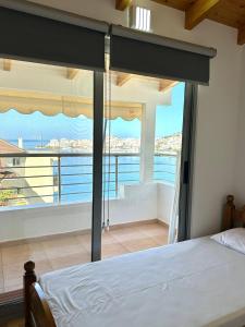 a bedroom with a bed and a view of the ocean at Spacious Lovely Apartment in Sarandë