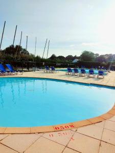 una grande piscina con sedie e sedie blu di Résidence Bretagne Douce excellent emplacement 300m de la mer ad Arzon Altre 32 foto