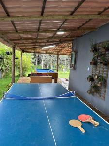 a ping pong table with two ping pong paddles on it at Sítio Recanto da Mata - Lagoa do Siri in Marataizes