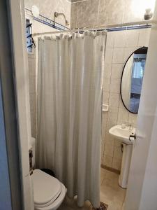 a bathroom with a shower curtain and a toilet at Casa Paso de la Patria in Corrientes