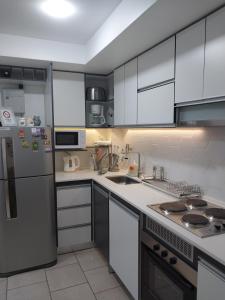 a kitchen with white cabinets and a stainless steel refrigerator at Ushuaia Extremo Sur in Ushuaia