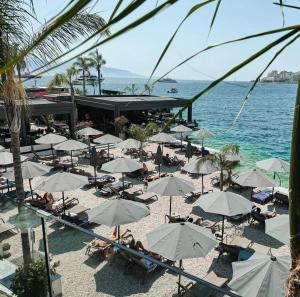 a beach with a bunch of umbrellas and the ocean at Spacious Lovely Apartment in Sarandë