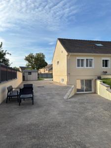 a patio with two benches in front of a house at confortable et spacieux 80m2 in Bailly-Romainvilliers
