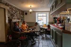 a group of people sitting at a table in a restaurant at The Bear inn in Llantrisant
