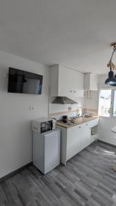 a white kitchen with white cabinets and a sink at La Cabaña Estudio pequeño in Fasnia