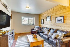 a living room with leather furniture and a flat screen tv at Lakefront Divide Cabin with Game Room! in Woodland Park