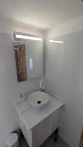 a white bathroom with a sink and a mirror at La Cabaña Estudio pequeño in Fasnia +8 photos