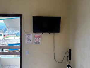 a flat screen tv on the corner of a wall at Encanto do Beija-flor in Angra dos Reis