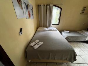 a bedroom with two beds and a window at Encanto do Beija-flor in Angra dos Reis