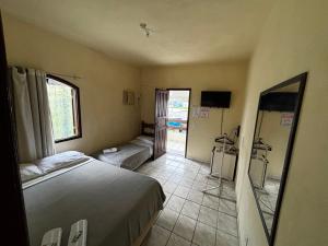 a hotel room with a bed and a mirror at Encanto do Beija-flor in Angra dos Reis