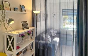 ein Zimmer mit einem Stuhl und einem Fenster mit einem Vorhang in der Unterkunft Lovely Apartment In Nexø With Sauna in Neksø + 18 Fotos