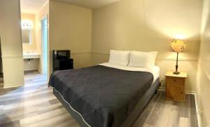 a bedroom with a bed and a lamp on a table at Harper Motel in Harper