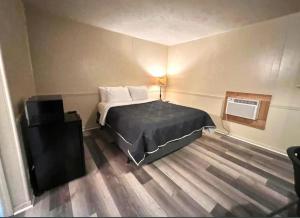 a small bedroom with a bed and a television at Harper Motel in Harper