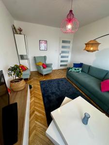 a living room with a green couch and a table at Apartament przy Rynku in Sandomierz