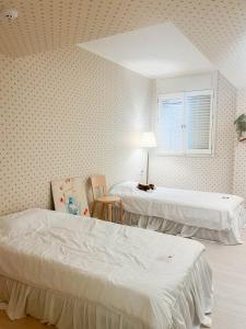 a bedroom with two beds and a window at Roots House in Busan