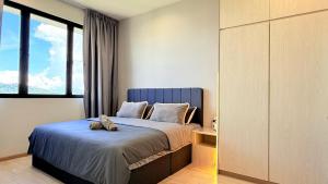 a bedroom with a bed and a large window at Iconic Regency Service Residences - Xin's Home in Bayan Lepas