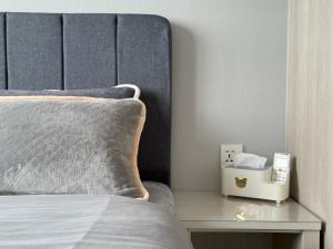 a close up of a bed with a nightstand next to it at Iconic Regency Service Residences - Xin's Home in Bayan Lepas