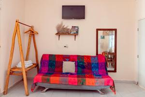 a living room with a colorful couch and a tv at MONOESPACIO a 2 cuadras de la estación de autobuses ADO in Tulum +7 photos