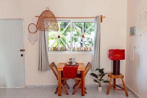 a table and chairs in a room with a window at MONOESPACIO a 2 cuadras de la estación de autobuses ADO in Tulum