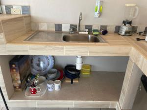 a miniature kitchen with a sink and some mugs at La Altanera in Troncones