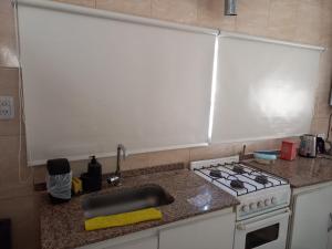 eine Küchentheke mit Herd und Spüle in der Unterkunft America in San Miguel de Tucumán