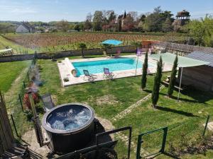 a backyard with a swimming pool and a hot tub at Maison avec jardin, piscine chauffée et baignade à proximité - Le Menoux - FR-1-591-234 in Le Menoux