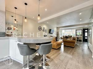 a kitchen and living room with a counter and chairs at Premium 3BR House, French Doors and Private Garden in Borehamwood