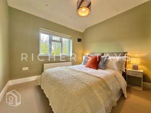 a bedroom with a bed and a window at Premium 3BR House, French Doors and Private Garden in Borehamwood