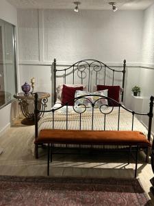 a bedroom with a metal bed with red pillows at Logement 1 pièce Cozy - Parfait pour Courts Séjours in Montreal