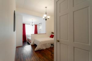 a room with a bed and a room with a door at Habitación triple confort - Casa Esmeralda in San José