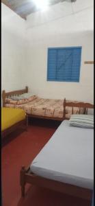 エルドラドにあるPousada Beira Rioの青い窓付きの部屋のベッド2台