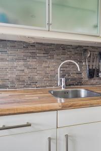 a kitchen with a sink and a brick wall at Huisje 118 bungalowpark Simpelveld in Simpelveld