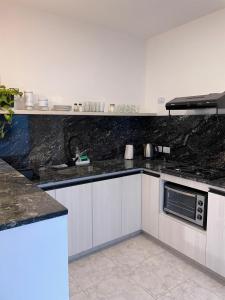 a kitchen with black granite counter tops and a sink at Torre Kalinka dos dormitorios pleno centro 6 personas in Villa Carlos Paz +4 photos