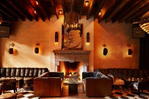 a room with a fireplace and leather chairs and a fire place at The Ludlow Hotel in New York