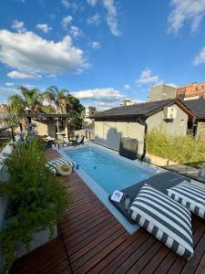 a swimming pool on a deck next to a house at Loft 1930 in Villa Carlos Paz