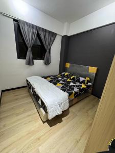 a bedroom with a bed and a wooden floor at F and M Homestay in Tuaran