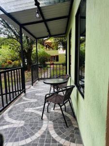 a patio with a table and two chairs on it at Cabina de las Hojas Monteverde in Monteverde Costa Rica +6 photos