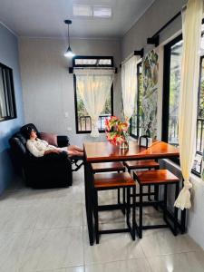 a woman laying on a couch in a living room at Cabina de las Hojas Monteverde in Monteverde Costa Rica
