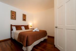 a bedroom with a bed with a brown blanket at Habitacion triple clasica - Casa Esmeralda in San José