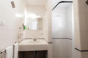 a white bathroom with a sink and a mirror at Habitacion triple clasica - Casa Esmeralda in San José +50 photos