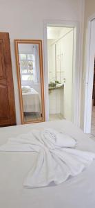 ナタールにあるYacht Village Praia JRの鏡の前のベッドに置かれた白いタオル