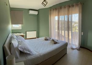 a bedroom with a bed with a cat laying on it at Serenity Residence in Anavyssos
