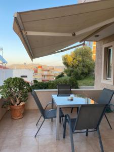 a patio with a table and chairs on a balcony at Serenity Residence in Anavissos