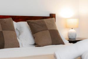 a bed with pillows and a lamp on a table at Habitacion doble delux - Casa Esmeralda in San José