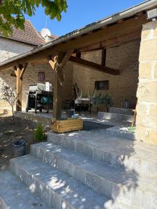 a stone patio with a wooden pergola at Family home with spa near Chantilly Paris in Angy