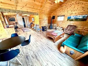 un soggiorno con divano e tavolo in una baita di tronchi di Aubin Sky Lodging at the YL Ranch a Savery