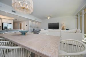 a kitchen and living room with a wooden table and chairs at Phoenix Gulf Towers 906 condo in Gulf Shores