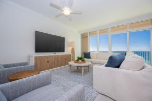 a living room with a couch and a tv at Phoenix Gulf Towers 906 condo in Gulf Shores +66 photos