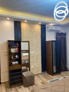 a living room with a mirror and a chair at Wealthy in Madīnat ash Shurūq +2 photos